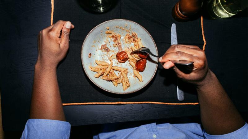 An overhead shot of a person eating pasta