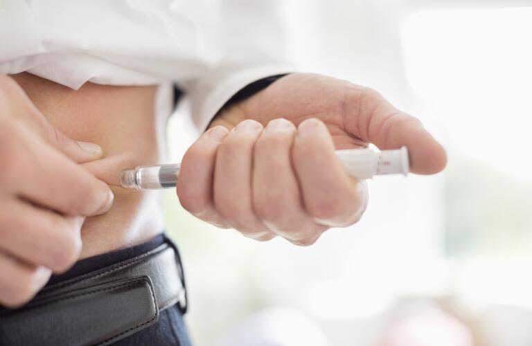 man injecting insulin into side