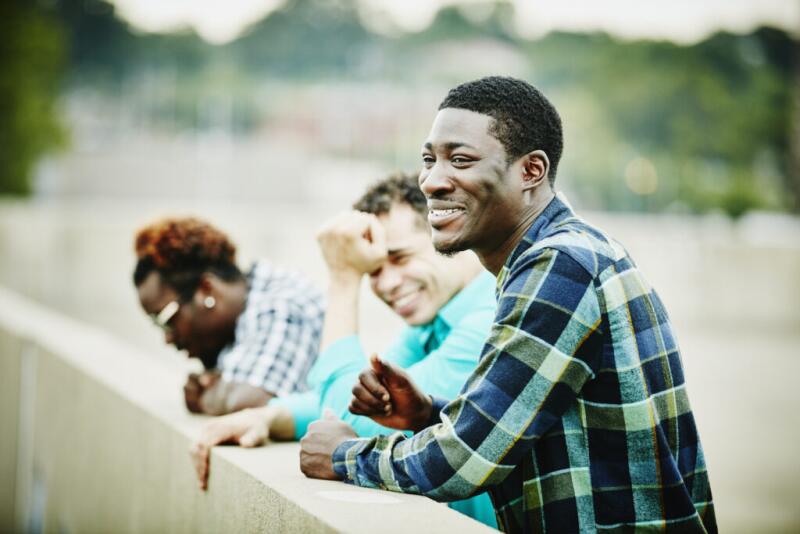 Laughing group of friends hanging out on rooftop