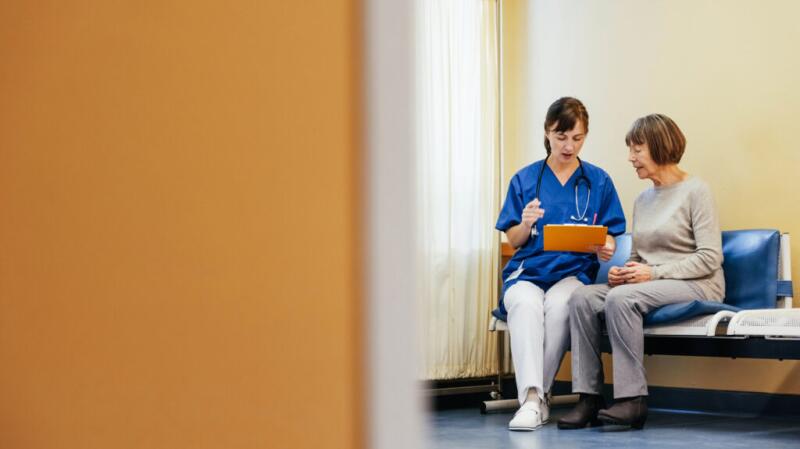 a doctor is talking to a woman in a hospital hallway