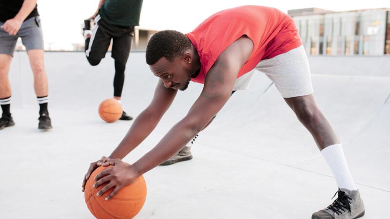 A man stretching with a basketball