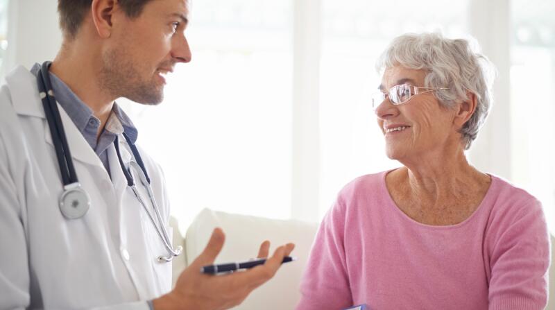 smiling-senior-woman-chatting-with-her-GP-during-an-appointment