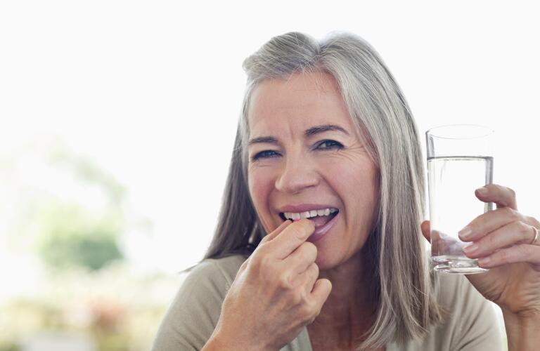 smiling woman taking vitamins