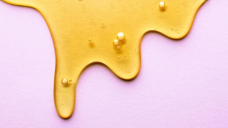 Honey dripping down a pink background