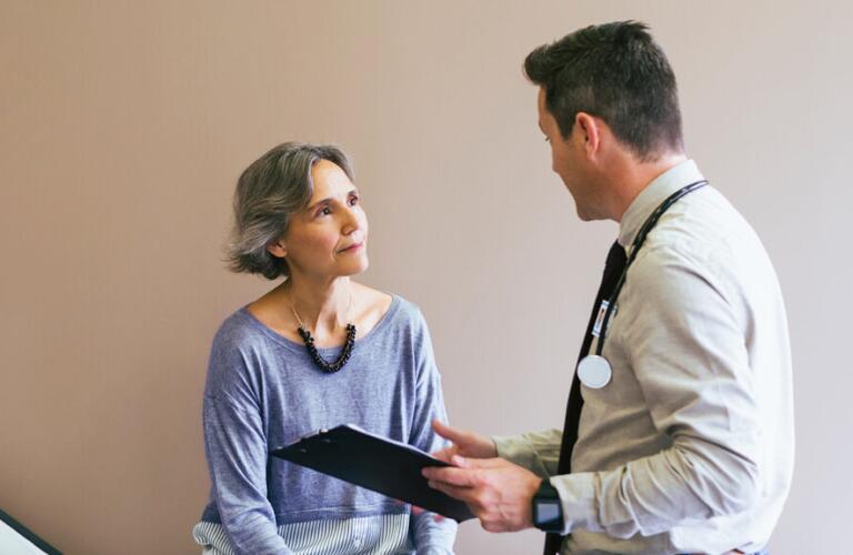 an older patient is talking to a doctor in a clinic