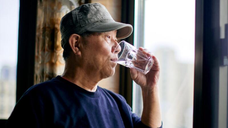 A person is drinking a glass of water.