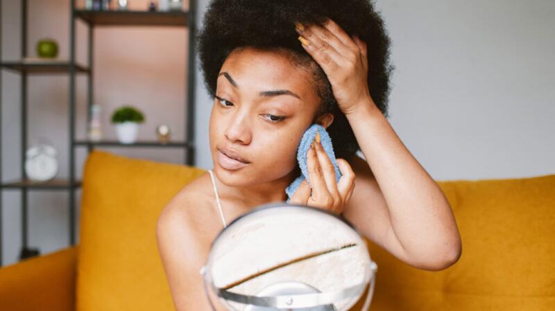 A woman is cleaning her face.