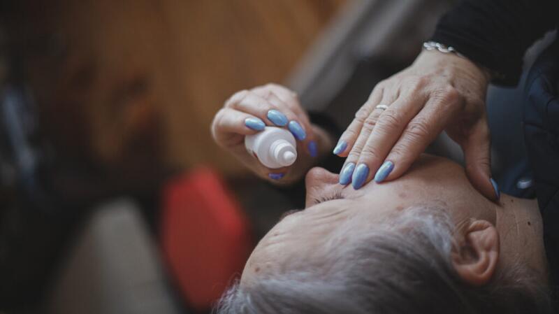 A person putting eyedrops in their eye