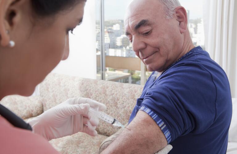 Senior man receiving shot in the arm
