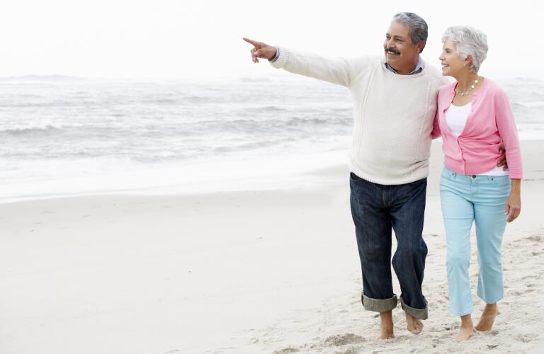 senior-couple-walking-on-beach