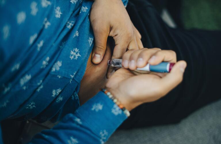 Man injecting medication into stomach