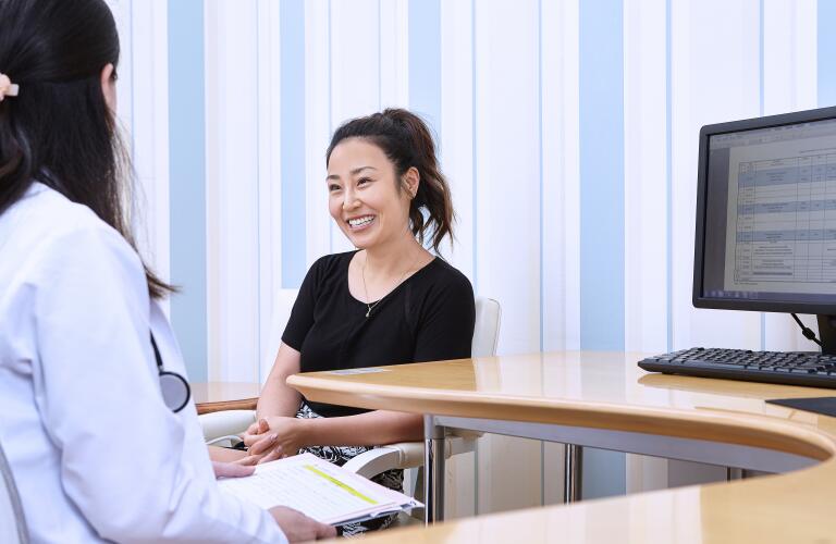 Young Asian American female patient talking to female doctor