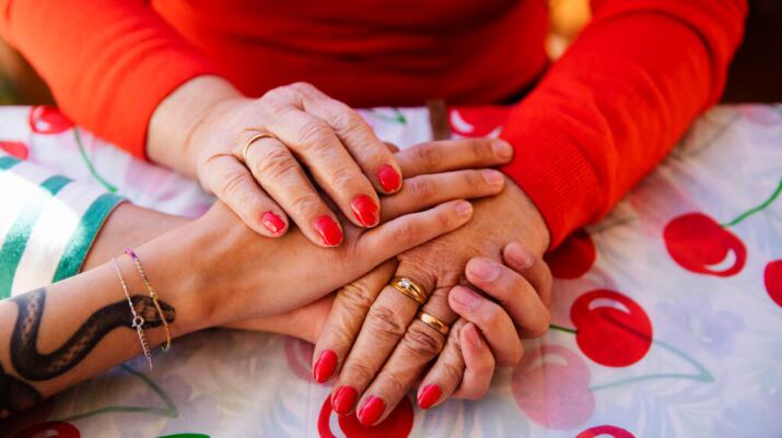 There is a closeup of women holding hands.