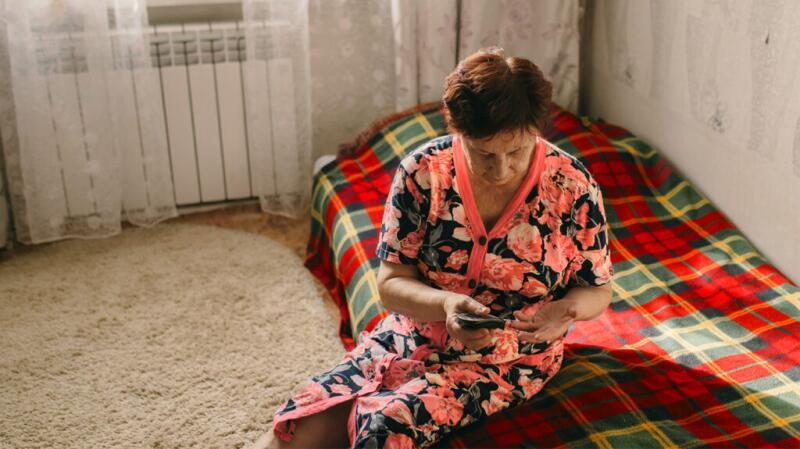 Woman sitting on bed checking blood sugar
