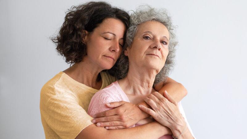 A mother and daughter are embracing.
