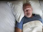 senior man sleeping on bed in bed