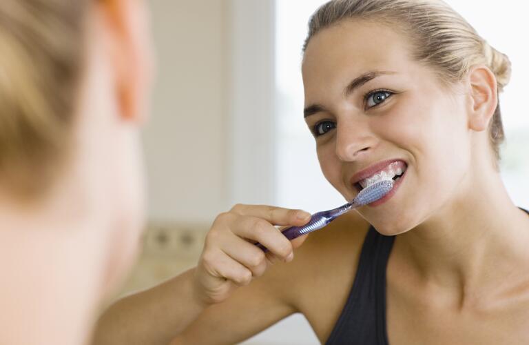 young woman brushing teeth