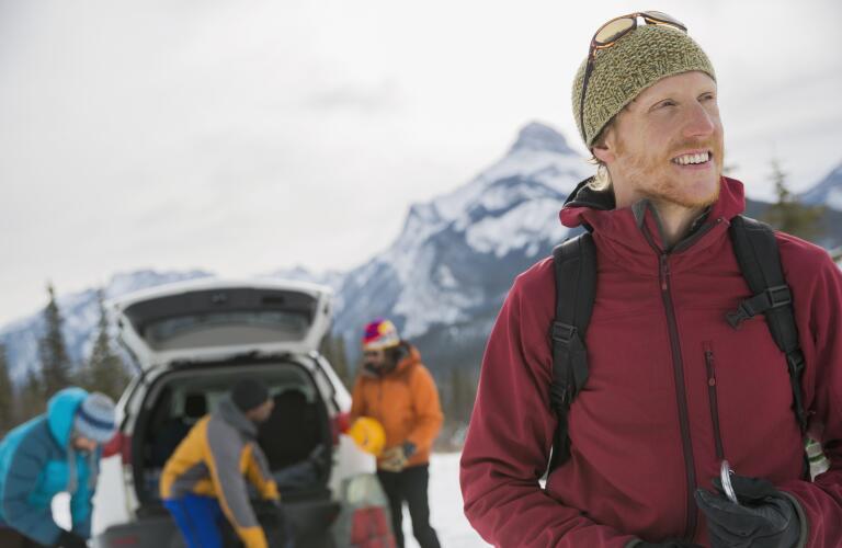 smiling man in winter weather ready for hike with friends