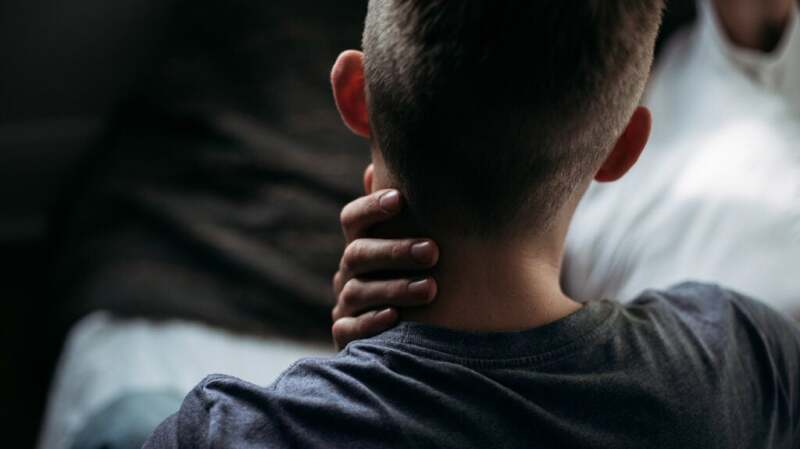 A person holding their hand to the side of their neck
