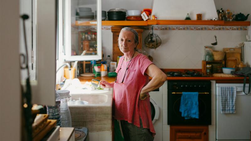 A woman is standing in a kitchen.