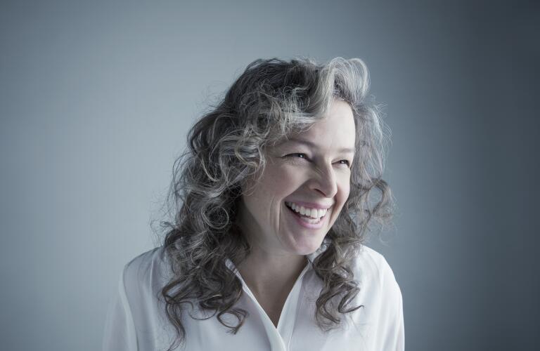smiling middle aged woman against gray background