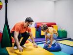 Boy exercising with physical therapist in sensory room 