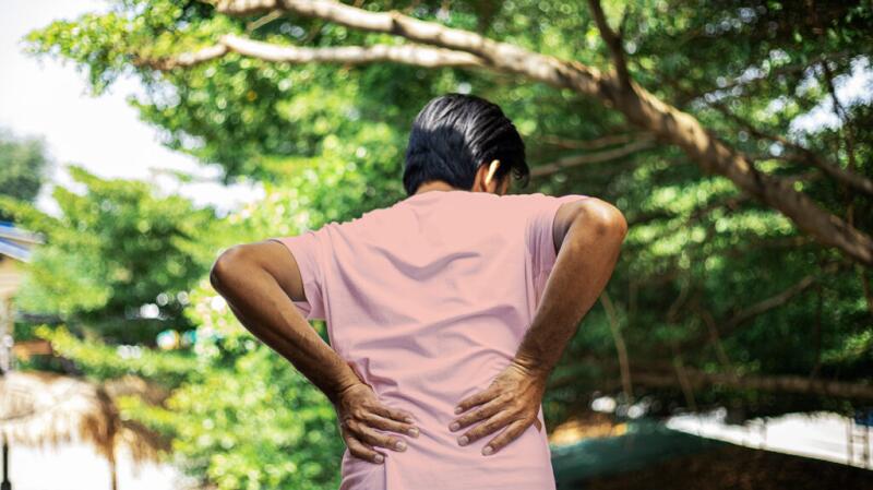 a person is touching their lower back