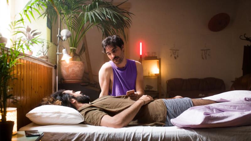 Male couple on bed talking