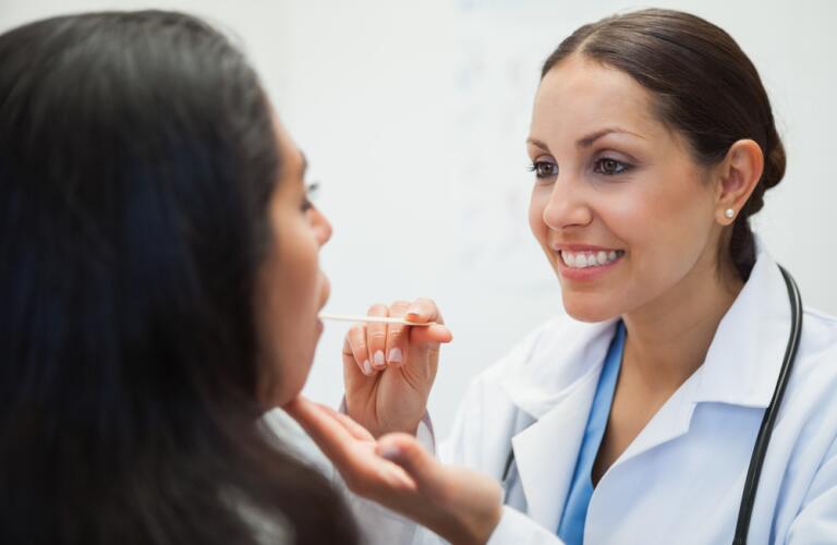 Woman doctor examining patients mouth