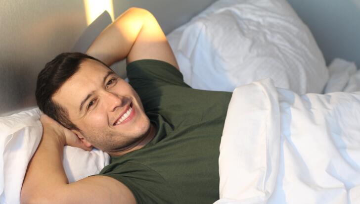 man waking up rested in the morning and smiling