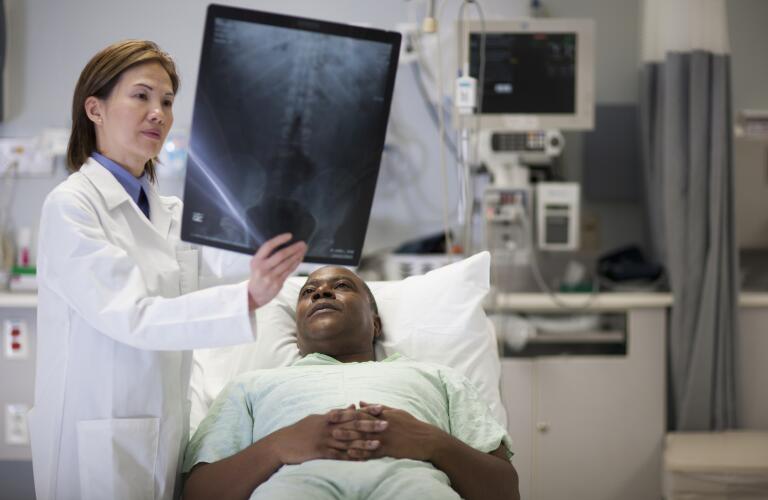 Doctor showing patient spine x-ray