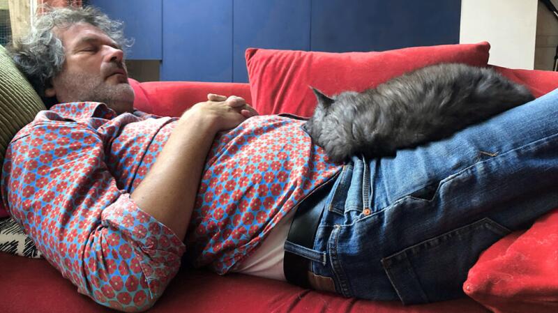 man napping on couch with cat on top