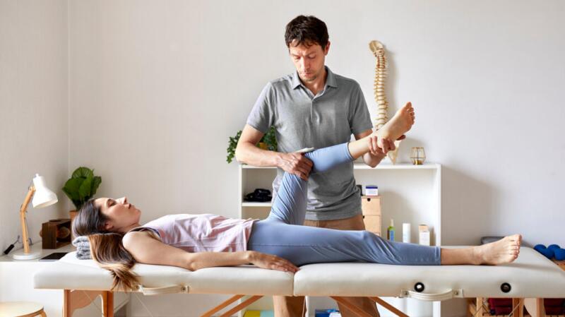 A clinician is holding a person's leg.