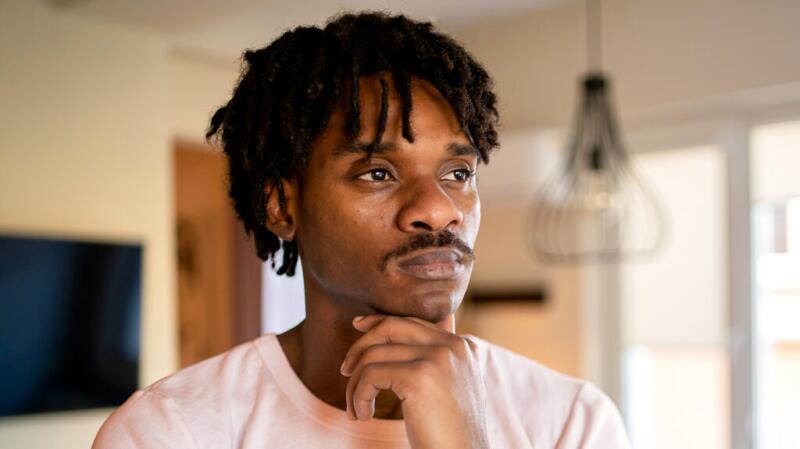 Male looking thoughtfully with hand rested near chin