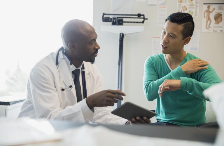 male doctor and patient with shoulder pain