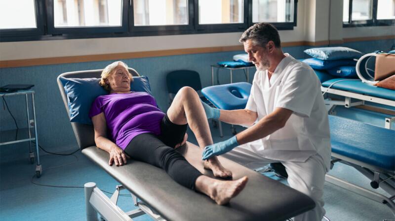 Woman lying on a medical bed being examined by a doctor