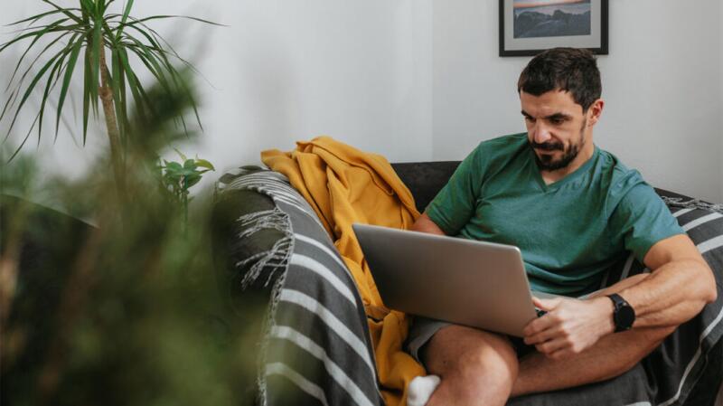 A man is looking at a laptop.