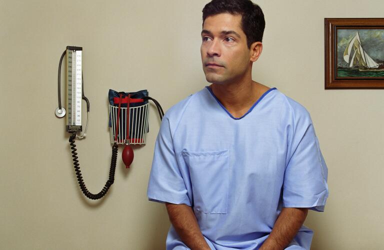 Male patient sitting on examining room table