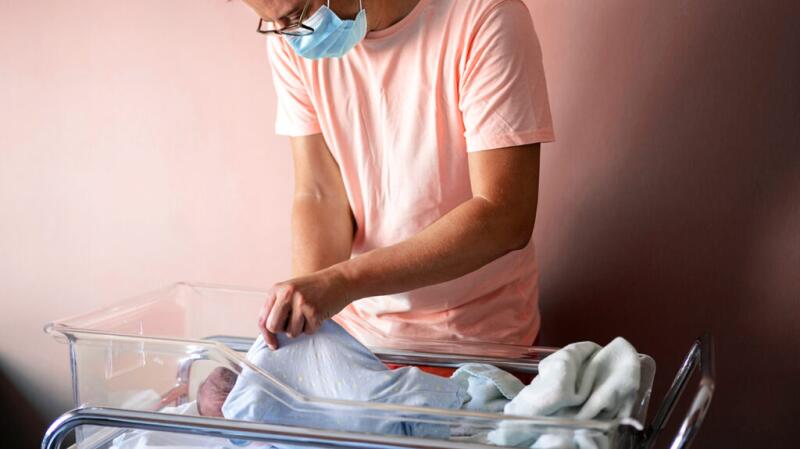 A father is looking at his newborn baby.