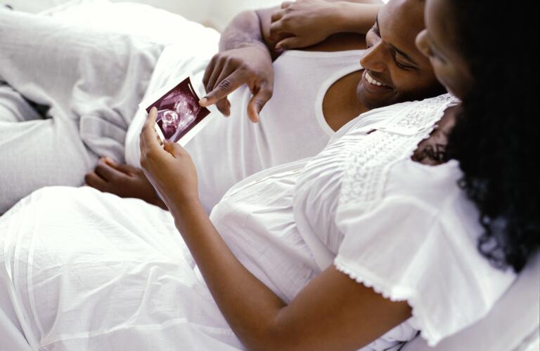 High angle side profile of a couple looking at their baby's ultrasound picture