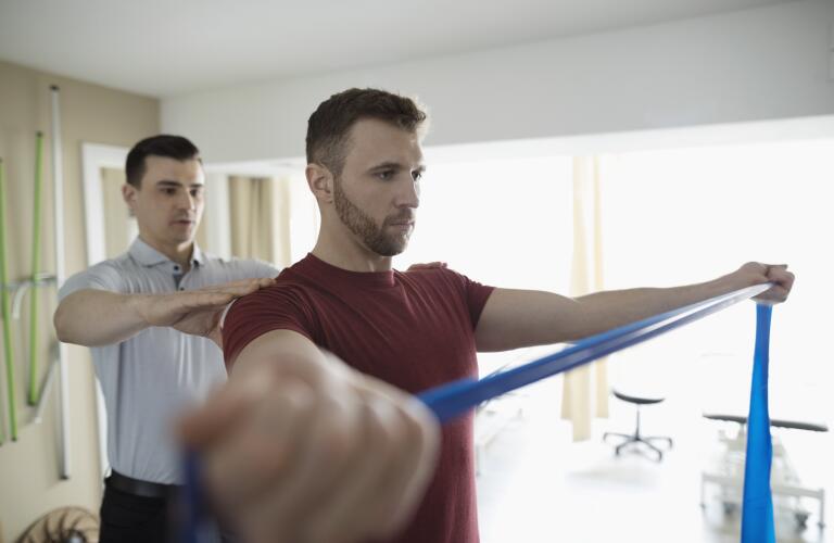 physical therapist with shoulder patient and theraband