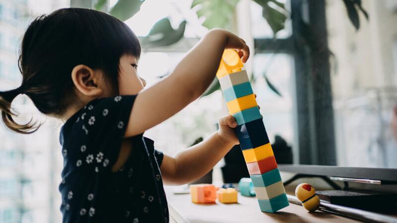 Young child playing with colored blocks