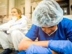 two exhausted health care workers sitting outside the hospital while taking a break