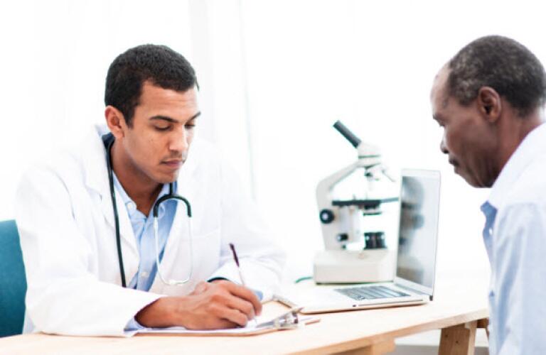 Senior man speaking with doctor at desk