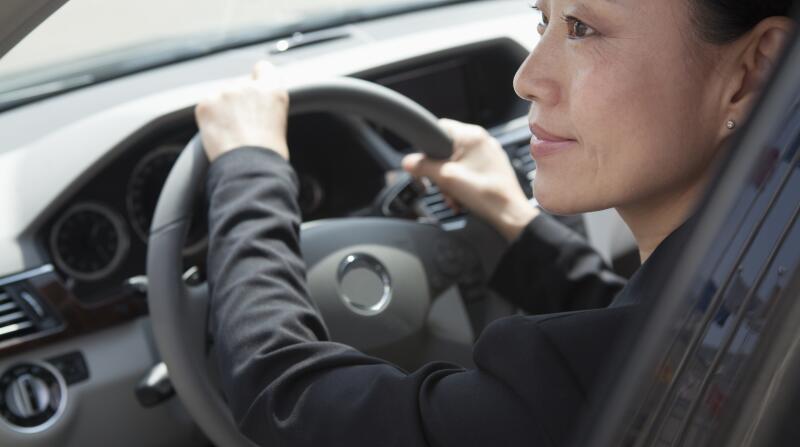 woman driving car looking out window