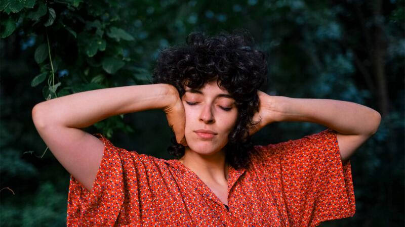 A woman is covering her ears with her hands