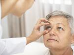 doctor checking senior female Caucasian patient's eye health