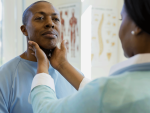 doctor examining male patient's glands