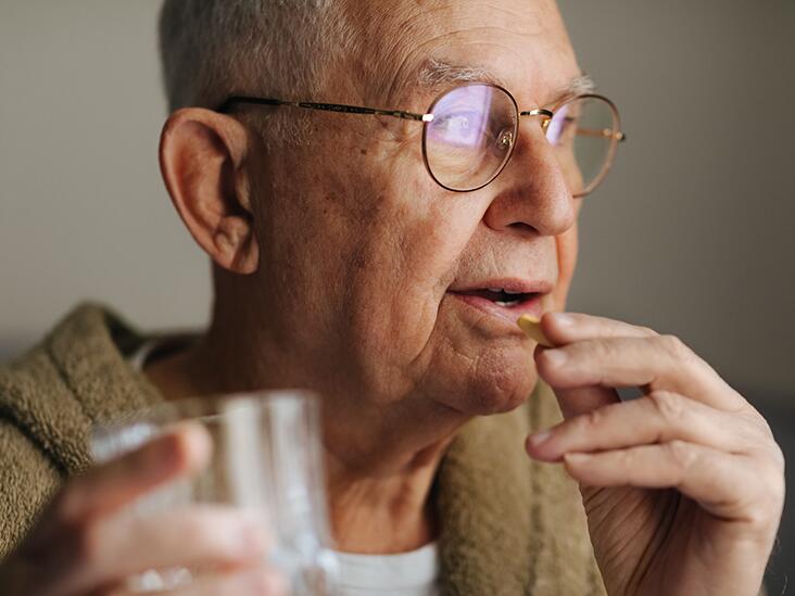 Man taking a pill with glass of water