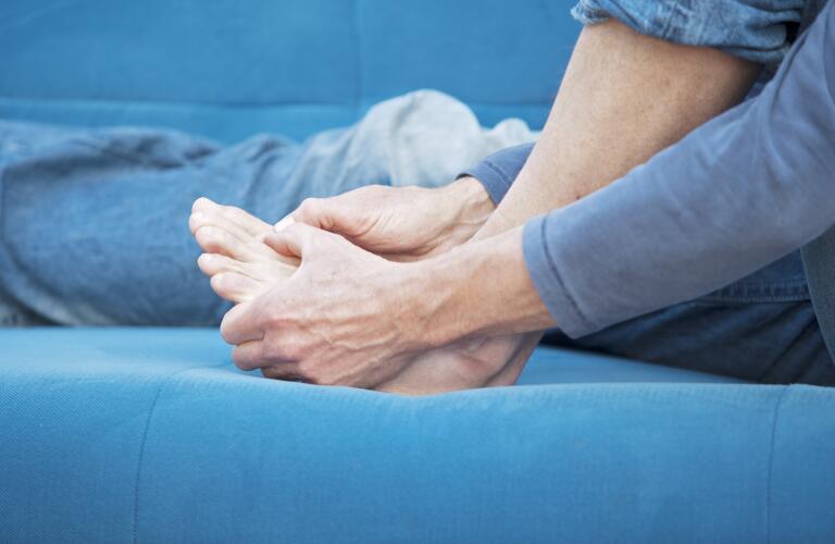 man holding big toe and foot in pain